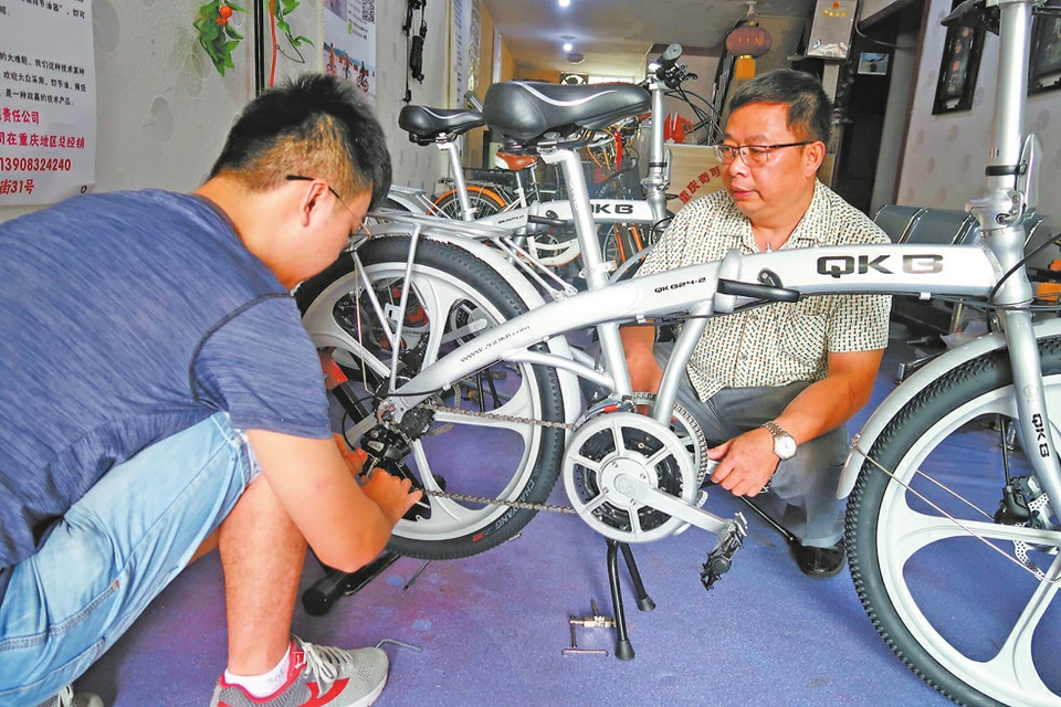 谢勇指导大学生安装新发明的自行车